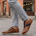 Lifestyle close-up of bugatti Sprinter cognac leather sneakers with black laces and zipper detail.