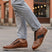 Lifestyle close-up of bugatti Sprinter cognac leather sneakers with black laces and zipper detail.