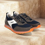 bugatti Cirino dark gray sneakers on stone steps, with white accents and orange translucent soles.
