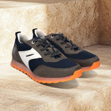 bugatti Cirino dark gray sneakers on stone steps, with white accents and orange translucent soles.