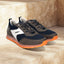 bugatti Cirino dark gray sneakers on stone steps, with white accents and orange translucent soles.