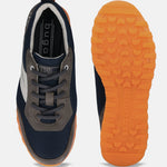 Dark grey running shoe by bugatti with navy mesh and orange rubber soles.