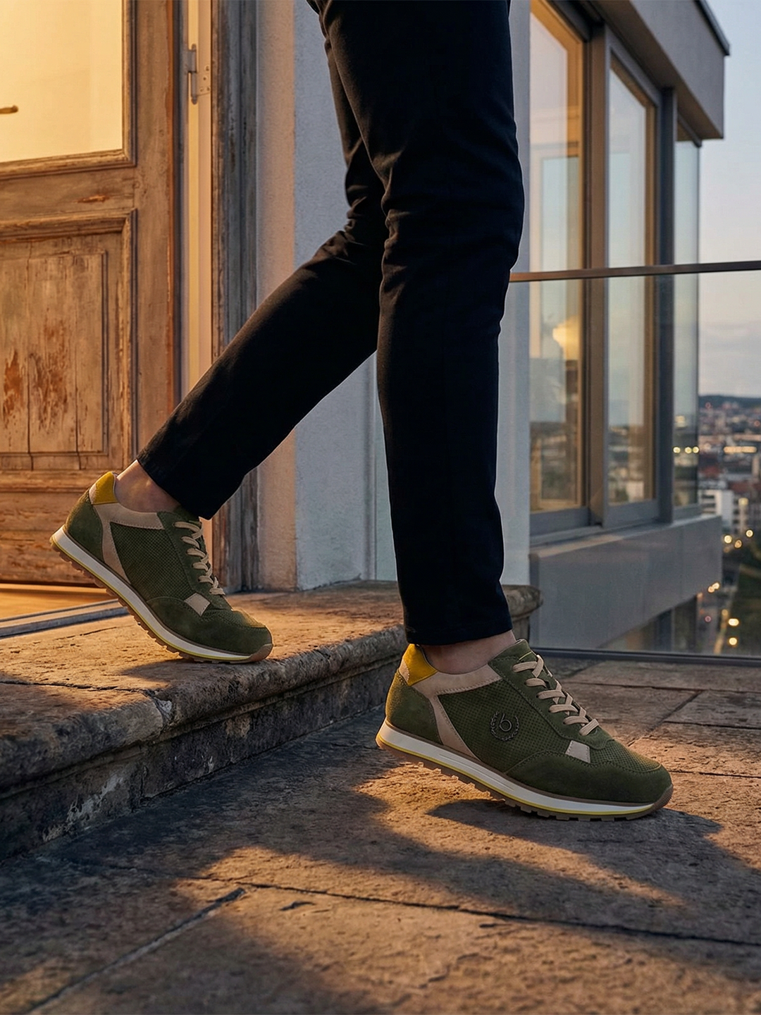 Lifestyle shot of bugatti Garnet Evo dark green leather sneakers with yellow and beige accents.
