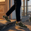 Lifestyle shot of bugatti Garnet Evo dark green leather sneakers with yellow and beige accents.

