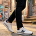 Lifestyle view of bugatti Garnet Evo white sneakers in premium leather, featuring navy accents and black pants.
