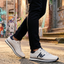 Lifestyle view of bugatti Garnet Evo white sneakers in premium leather, featuring navy accents and black pants.
