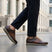 Lifestyle view of bugatti Garnet Evo dark brown premium leather sneakers with dark pants on a city street.