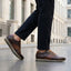 Lifestyle view of bugatti Garnet Evo dark brown premium leather sneakers with dark pants on a city street.
