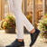 Lifestyle close-up of bugatti Sione Comfort dark blue casual shoes worn with white pants.
