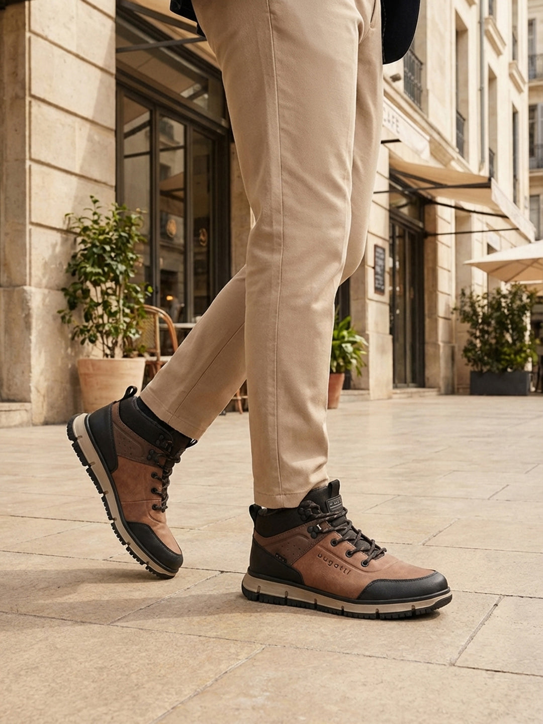 Person wearing A cognac Men's bugatti Outdoor Sneakers featuring a round toe plain toe, zero heels heel. Made from synthetic with a durable eva outsole, this laces design offers both style and comfort. on a city street.