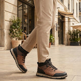 Person wearing A cognac Men's bugatti Outdoor Sneakers featuring a round toe plain toe, zero heels heel. Made from synthetic with a durable eva outsole, this laces design offers both style and comfort. on a city street.