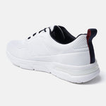 White sneaker by bugatti with black interior, laces, and a navy blue heel pull tab with a red stripe.