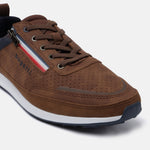 Brown casual sneaker by bugatti with a red, white, and blue stripe, brown laces, and perforated leather texture.