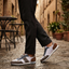 Lifestyle view of bugatti Ross multicoloured sneakers with grey and brown accents, styled with black trousers.