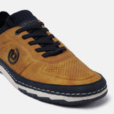 Yellow low top sneaker by bugatti with a perforated toe, navy blue accents, and black laces.