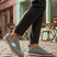 Grey low top sneakers by bugatti with a knit texture and white accent stripes, worn with dark grey pants.