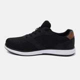 Black comfort sneaker by bugatti with a mesh and suede upper, and a brown heel accent, in a side view.
