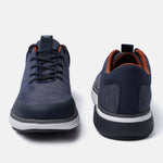 Dark blue comfort mid top sneakers by bugatti with a textured knit upper and brown trim around the ankle.