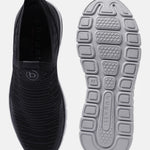 Black comfort sneakers by bugatti, featuring a knit upper and a patterned rubber sole.