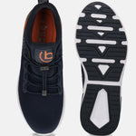 Dark blue athleisure sneakers by bugatti with orange accents, shown with visible soles.