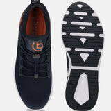 Dark blue athleisure sneakers by bugatti with orange accents, shown with visible soles.