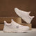 Beige bugatti Adelson Comfort Sneakers with breathable mesh and synthetic suede, presented on wooden display blocks.
