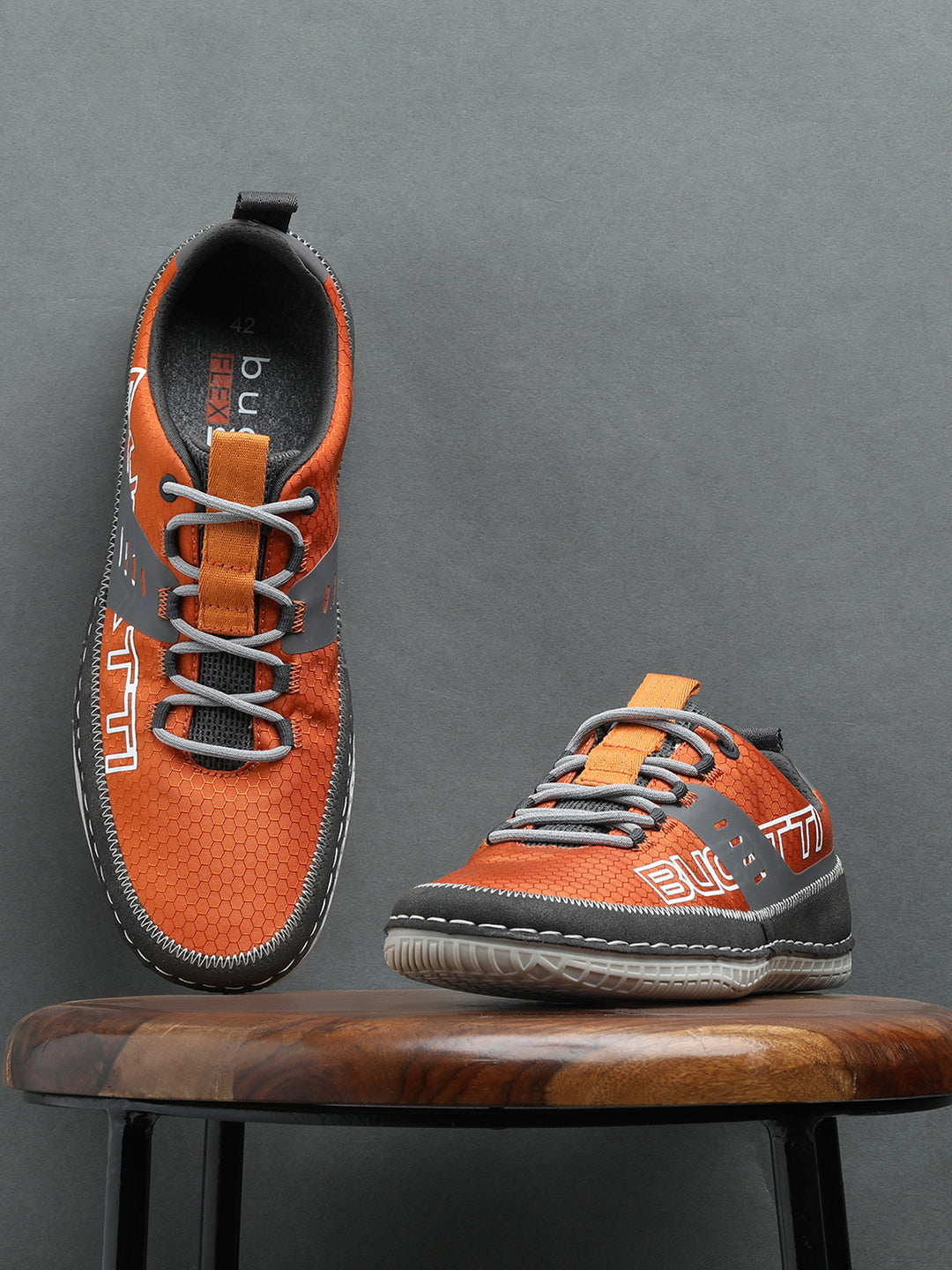 Orange comfort low-top sneakers by bugatti with gray accents and textured patterned details.